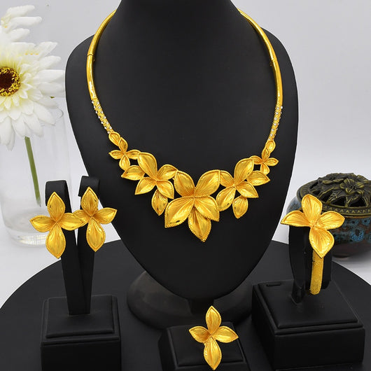 Women's four-piece gold-tone jewelry set with floral designs, including a necklace, bracelet, ring, and earrings.