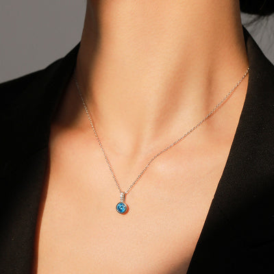 Women's light luxury jewelry set with a silver-toned necklace and hoop earrings, each featuring a sea blue artificial diamond pendant and clear artificial diamo