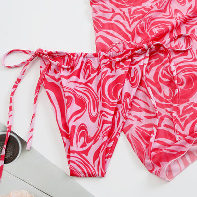 Women's three-piece swimsuit in red and orange abstract swirl print, featuring a halter bikini top, tie-side bottoms, and a ruched mini skirt. - Image 14