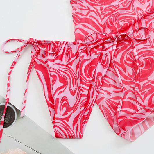 Women's three-piece swimsuit in red and orange abstract swirl print, featuring a halter bikini top, tie-side bottoms, and a ruched mini skirt. - Image 14
