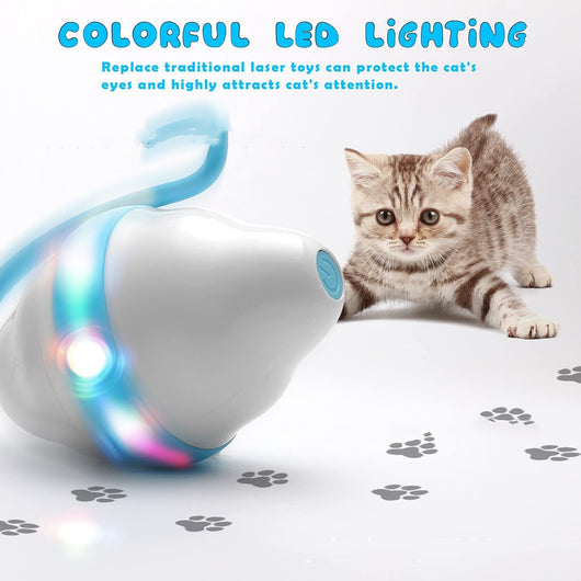 Golden-brown cat playing with a white and grey automatic rolling mouse cat toy with feather-like streamers on a wood floor. - Image 9