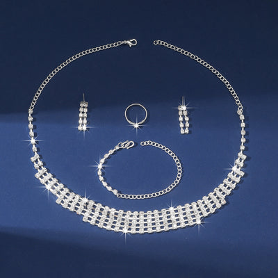 Sparkling four-piece jewelry set with a rhinestone necklace, bracelet, drop earrings, and a simple band ring on a model. - Image 3