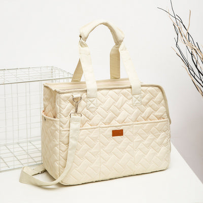 Cream quilted portable pet carrier with top handles, detachable shoulder strap, front pocket, and ventilation mesh. - Image 5