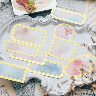 Assorted decorative paper labels with gold foil borders and soft watercolor designs in pink, blue, and green hues. - Image 2