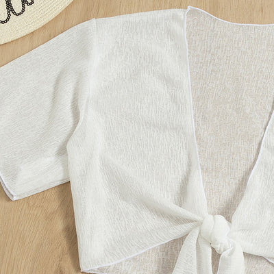 White two-piece swimwear set with a tie-front crop top and a high-waisted skirt with an asymmetrical ruffled hem. - Image 2