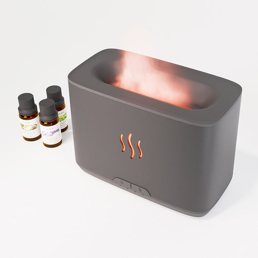 Dark gray rectangular aromatherapy humidifier with an orange flame-like mist and three essential oil bottles. - Image 7