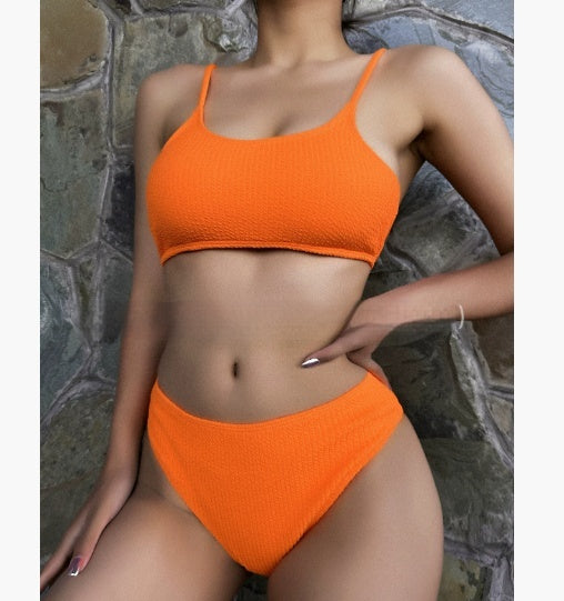 Women's casual orange textured bikini set with scoop neck top and high-cut bottoms against a stone wall. - Image 21