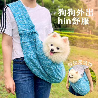 Person in white hoodie carrying a happy white dog in a navy blue pet sling bag outdoors. - Image 11