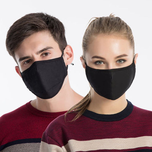 Young man wearing a black cotton face mask with adjustable ear loops, suitable for warmth and dust protection.