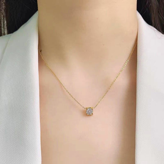 Delicate silver-colored chain necklace with a single square-cut clear stone pendant in a four-prong setting on a woman's neck. - Image 12