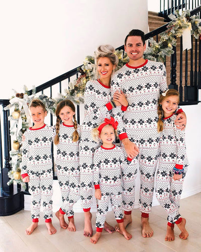 Family of six wearing matching white and red Christmas pajamas with snowflake and fair isle patterns. - Image 8