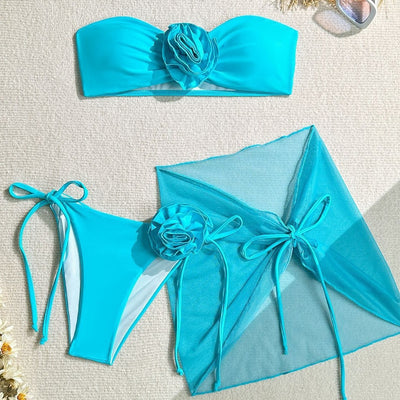 Women's blue tube top swimsuit with a large 3D flower, tie-side bikini bottoms, and a sheer sarong skirt. - Image 5