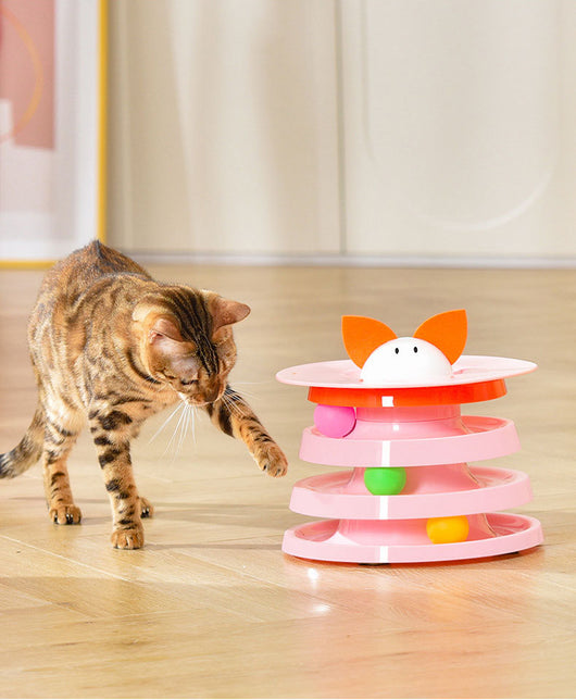 Brown tabby cat sniffing a black and orange multi-level rotating cat plate toy with colorful balls and bunny ears. - Image 15