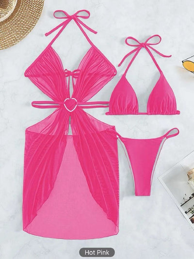White three-piece halter neck bikini and sheer cover-up set with a heart-shaped embellishment, laid flat on wood. - Image 8