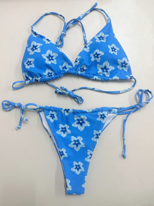 Blue floral print string bikini with triangle top and tie-side bottoms on a model in shallow ocean water. - Image 15
