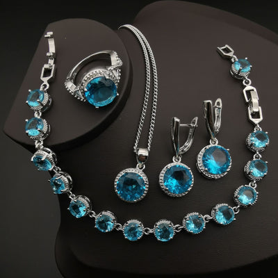 Four-piece silver-tone jewelry set with round green gemstones, including a necklace, bracelet, ring, and dangle earrings. - Image 11