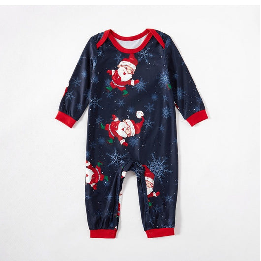 Family of four wearing matching navy blue Christmas pajamas with Santa Claus and snowflake print, red trim. - Image 9