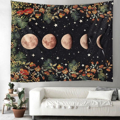 Black tapestry with moon phases and stars, bordered by orange and green floral patterns, hanging above a white sofa. - Image 2