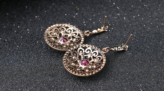 Vintage-style jewelry set with a necklace and matching drop earrings. Features red and clear gemstones in an antique gold-tone filigree design. - Image 7