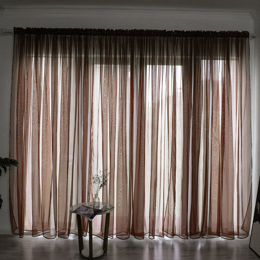 Simple and modern black sheer gauze curtain hanging on a rod in front of a window, filtering light. - Image 2