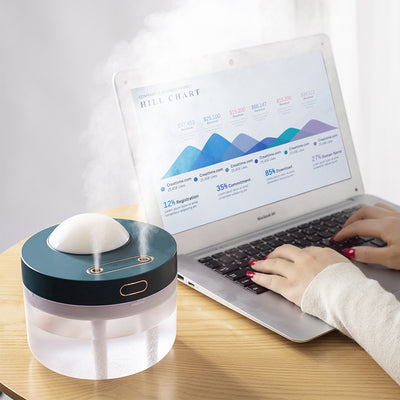 White portable projection humidifier with a translucent water tank and gold-accented control buttons. - Image 5