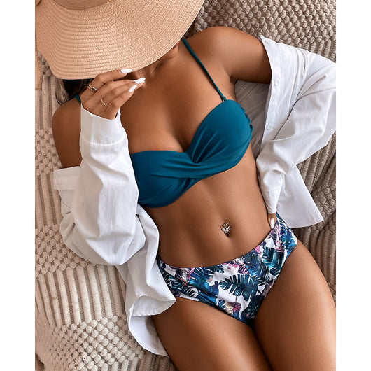 Teal twisted bandeau bikini top with tropical leaf print high-waisted bottoms on a model wearing a white shirt. - Image 17