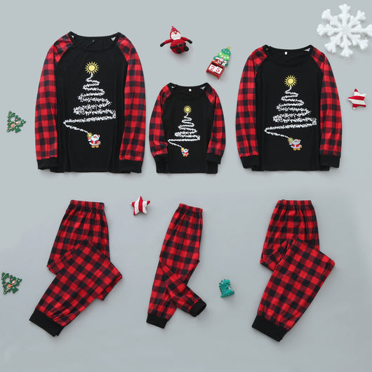 Family of five wearing matching black and red buffalo plaid Christmas pajamas with a white Christmas tree print.