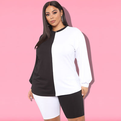 Woman wearing a black and white color-block long-sleeve top and matching shorts with white sneakers. - Image 27