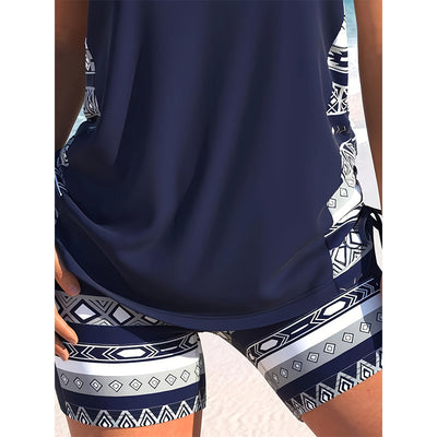 Women's navy blue tankini swimsuit with geometric pattern, criss-cross V-neck, and matching swim shorts. - Image 3