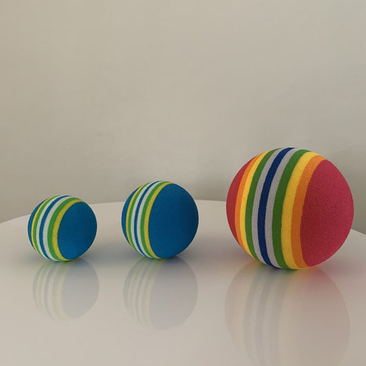 Set of three red pet play balls with rainbow stripes in varying sizes, made from soft EVA material. - Image 3