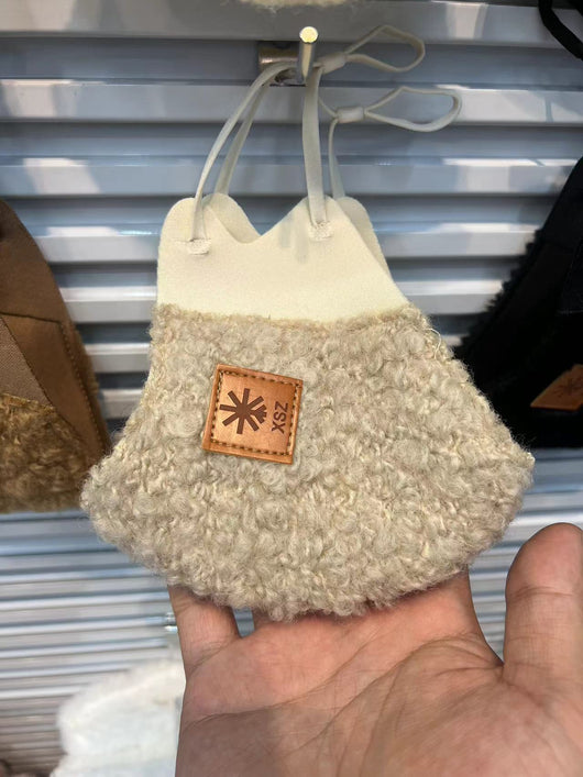 Beige curly plush warm mask with cream trim and a brown faux leather patch, held by a hand. - Image 13