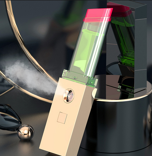 Two sleek black and gold nano spray water replenishing instruments on a dark, reflective surface.