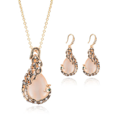 Rose gold tone bridal jewelry set with a necklace and stud earrings, each featuring a large blue teardrop gem and clear accents. - Image 10