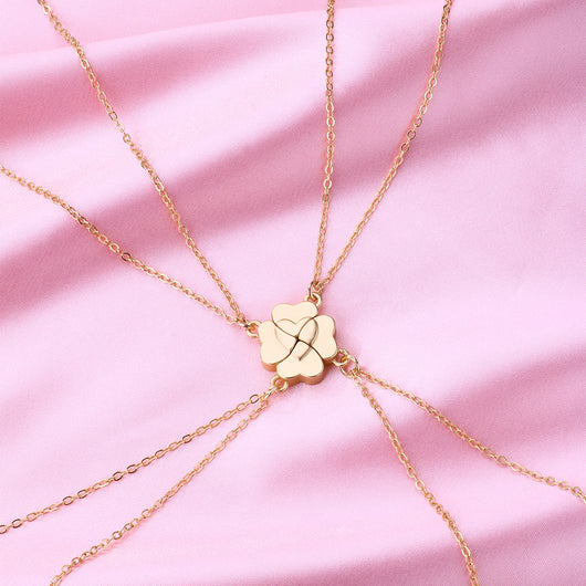 Four silver-colored necklaces, each with a half-heart charm that forms a four-leaf clover when combined, on pink satin. - Image 12