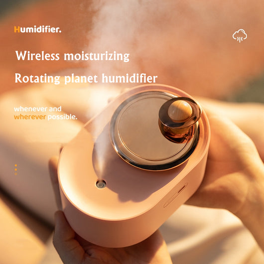 White USB rechargeable mini humidifier with a rose gold top accent and a wooden planet decoration. - Image 12