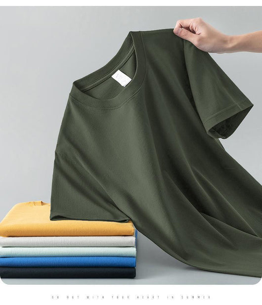Light gray short-sleeve t-shirt with a round neck, held up to show its smooth fabric. A stack of folded t-shirts in various colors is visible in the background. - Image 27