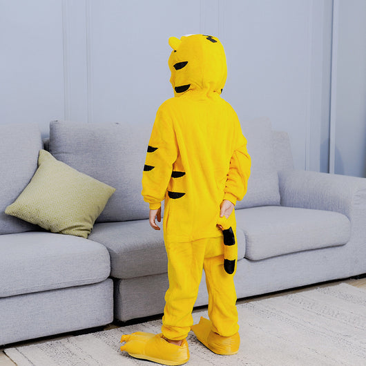 Young child in a yellow tiger hooded flannel pajama jumpsuit with white belly and black stripes, standing indoors. - Image 11