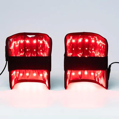Two red light therapy wristbands with multiple bright LED lights and black adjustable straps, emitting a red glow.
