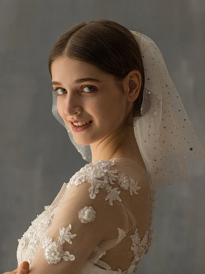 White multi-layer short bridal veil with gold star embellishments, worn by a model in a white lace wedding dress. - Image 9