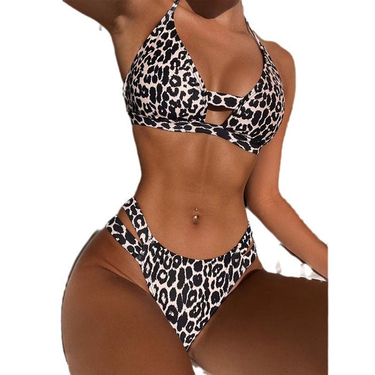 Leopard print high-waisted bikini with a halter neck top and front cutout, worn by a woman lounging outdoors. - Image 14