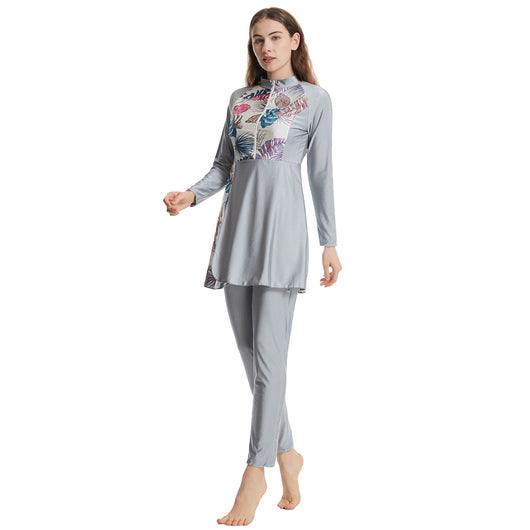 Woman in a navy blue quick-drying conservative swimwear set with a tropical leaf print tunic and matching swim cap. - Image 13
