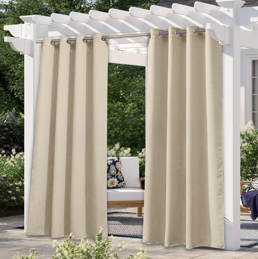 Solid gray outdoor curtain panels with grommet tops hanging from a white pergola on a sunny patio.