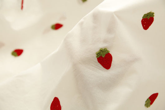 White pure cotton fabric with embroidered red cherries and green leaves, draped to show texture. - Image 5