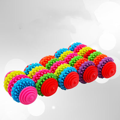 A hand holds a colorful rubber dog toy ball with seven interlocking gear-like rings in purple, orange, green, red, yellow, pink, and blue. - Image 6