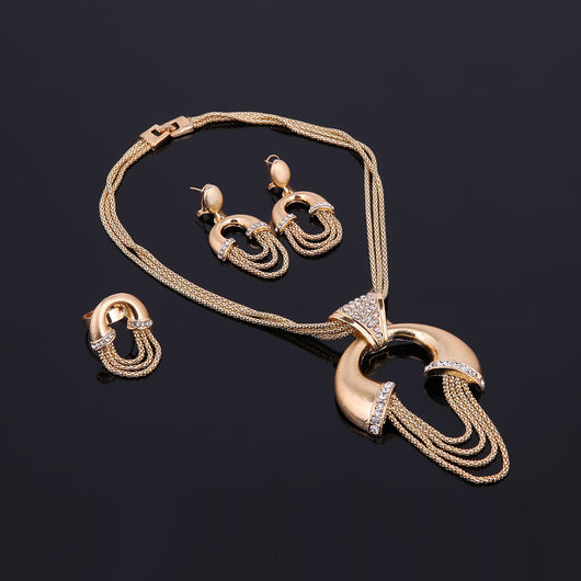 Four-piece gold-tone bridal jewelry set with crystal accents, including a statement necklace, dangling earrings, bracelet, and ring. - Image 11