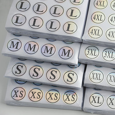 Stack of round clothing size stickers with laser color-changing background and black text, from XS to 4XL. - Image 17