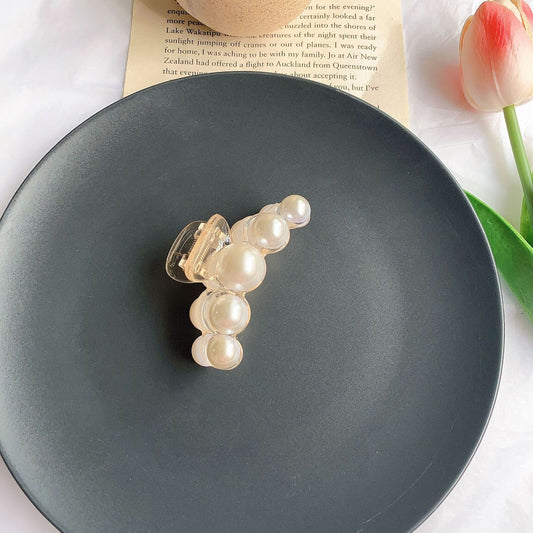 Clear plastic hair claw clip adorned with a single row of white faux pearls and a gold-toned spring. - Image 2