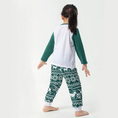 Woman in a Christmas pajama set with a white top, green sleeves, dinosaur graphic, and green fair isle pants. - Image 27