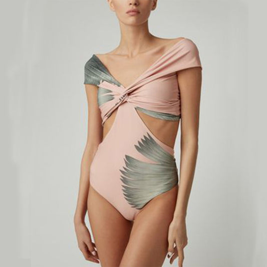 Women's vintage pink off-the-shoulder swimsuit with twisted front, cut-outs, and gray feather print.