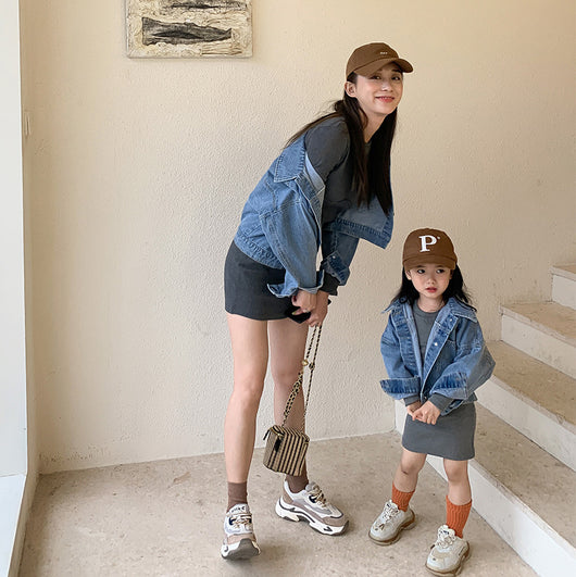 Woman and child in matching outfits: light blue denim jackets and dark gray knitted mini dresses, with baseball caps and sneakers. - Image 9